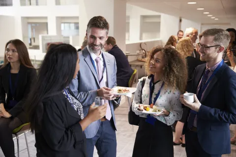 A group of mental health counselors have a conversation during a conference.